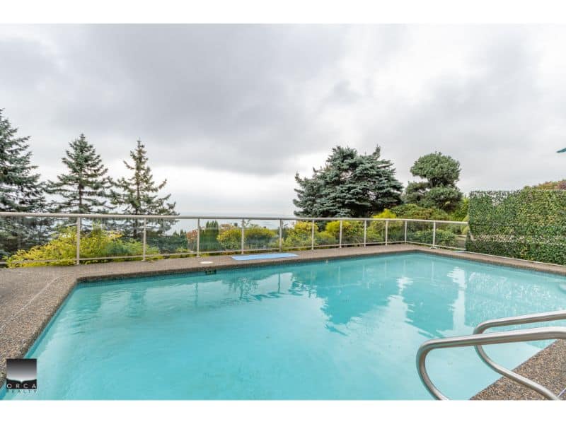 Luxurious outdoor swimming pool with scenic forest views, perfect for relaxation and entertaining in Victoria, BC. Enjoy modern amenities and a beautiful landscaped yard.