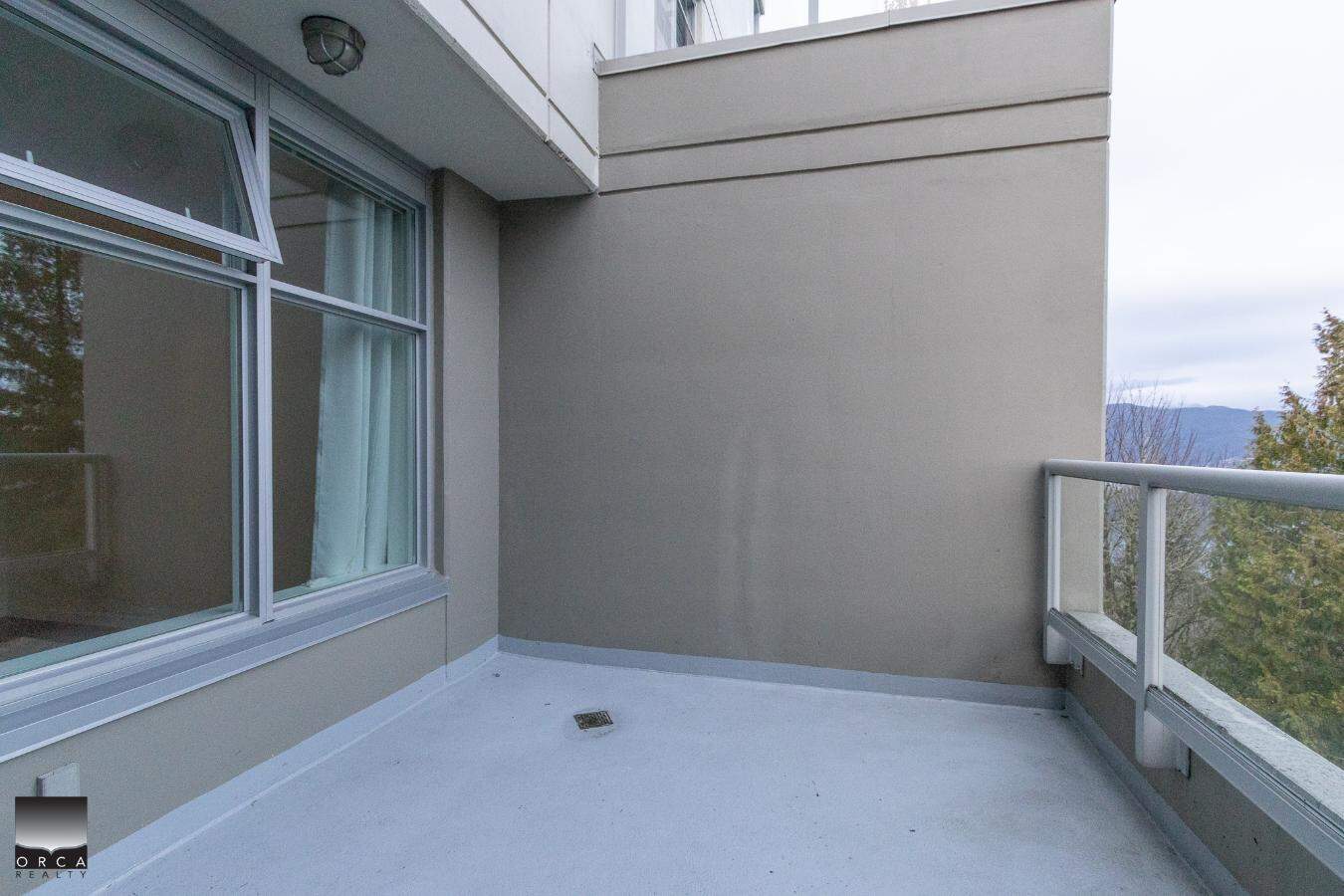 Spacious balcony with glass railing and scenic mountain view, ideal for outdoor relaxation and entertaining in Vancouver's vibrant real estate market.