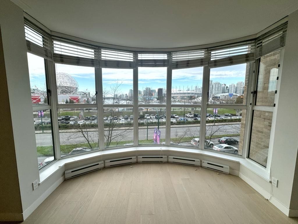 Modern corner balcony with expansive Vancouver city skyline views, large windows, and natural light, perfect for urban living or investment properties in Vancouver.