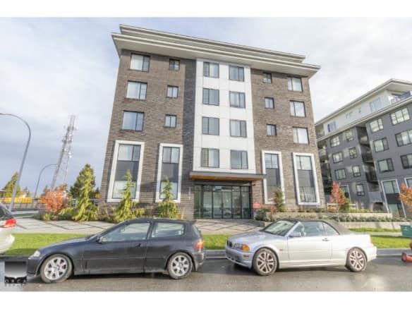 Modern apartment building exterior in Vancouver with large windows and landscaped garden, showcasing contemporary urban living.