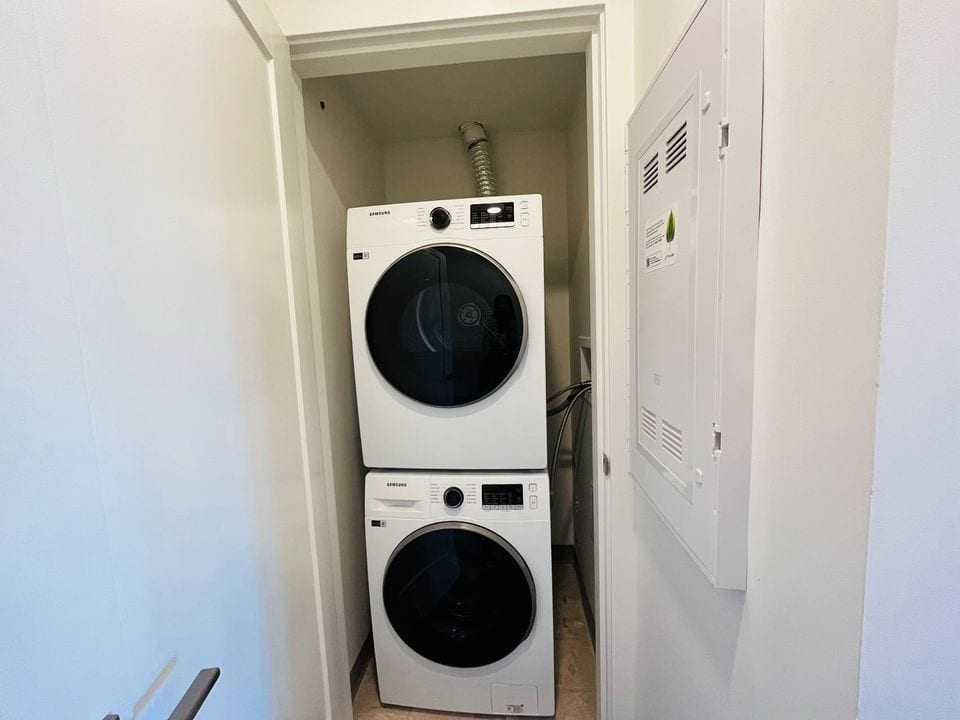 Stacked washer and dryer units in a laundry closet at a residential property.