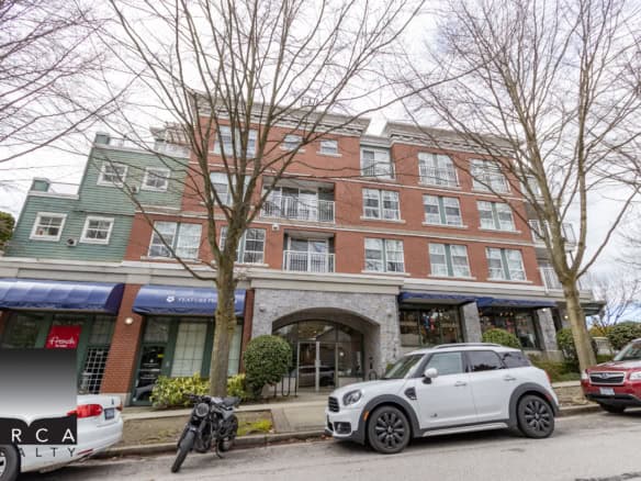 Modern mixed-use commercial and residential building in Vancouver with retail stores on the ground floor, featuring brick and green siding exterior.