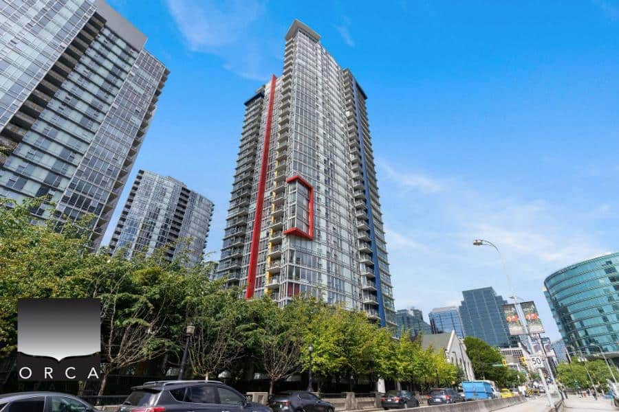 Modern high-rise condominium building in downtown Vancouver, BC, showcasing luxury real estate and urban living options offered by Orca Realty Inc.