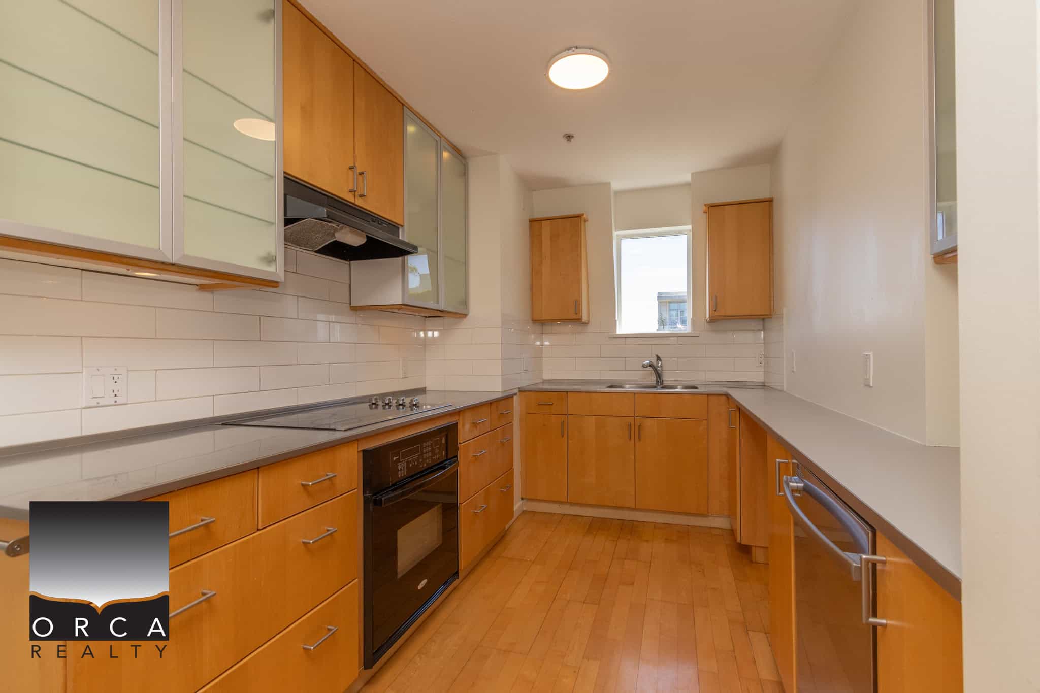 Bright modern Vancouver kitchen with maple cabinets, stainless steel appliances, and white subway tile backsplash, perfect for urban living.
