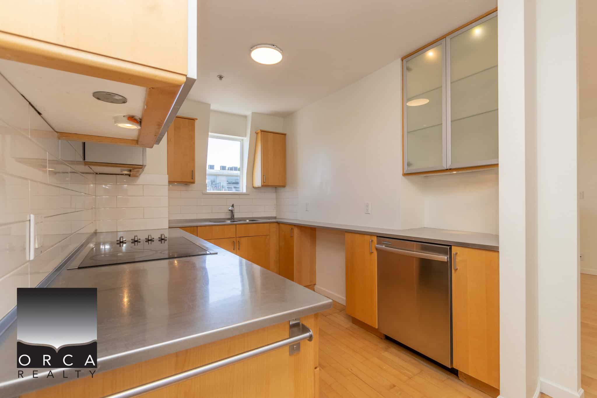 Modern kitchen with wooden cabinets, stainless steel appliances, and white subway tile backsplash, ideal for Vancouver propertybuyers seeking stylish real estate options.