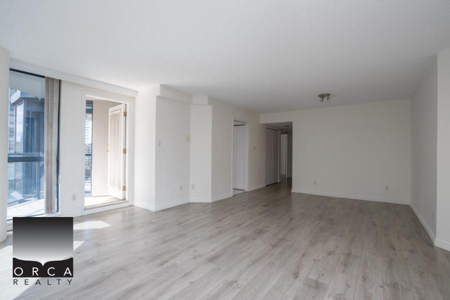 Bright modern living room with large windows and balcony access, showcasing contemporary design and natural light, perfect for comfortable city living in Vancouver.