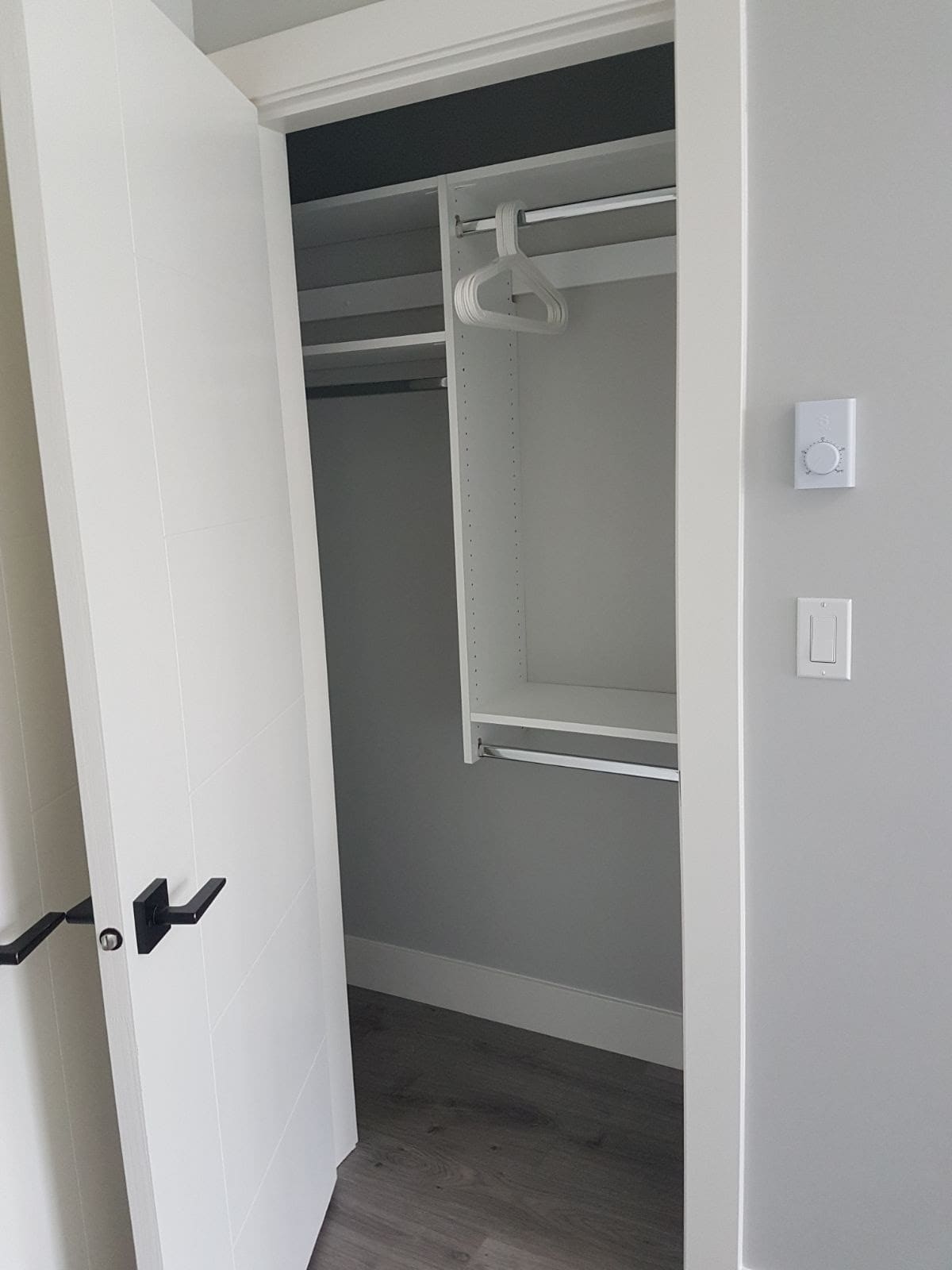 12 Open white closet with hanging rods and empty space for storage and clothes organization in a modern home.