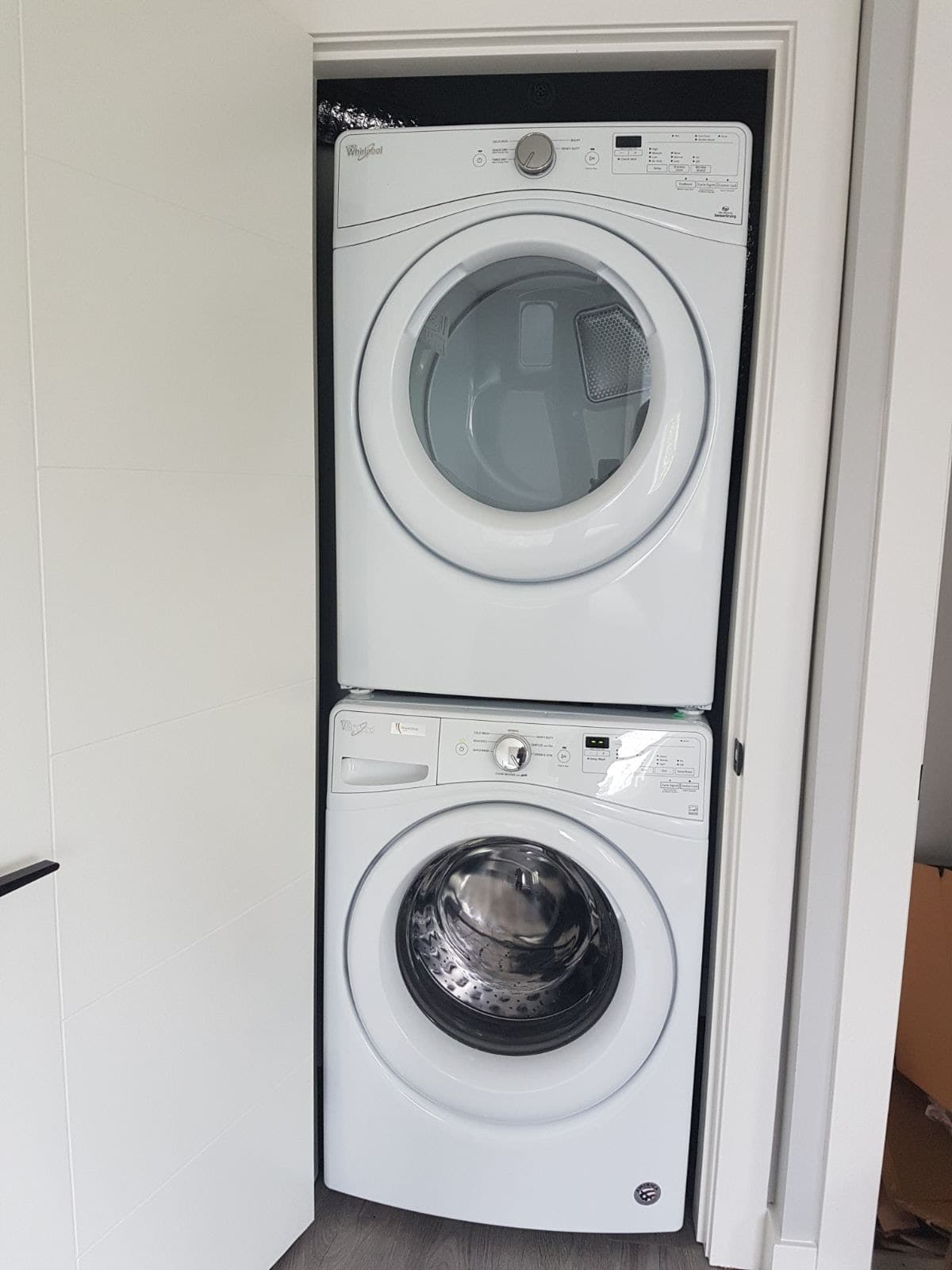 13 Clean white front-loading washer and dryer stacked in a modern laundry space for residential or rental properties in Vancouver. Perfect for real estate listings or property management.