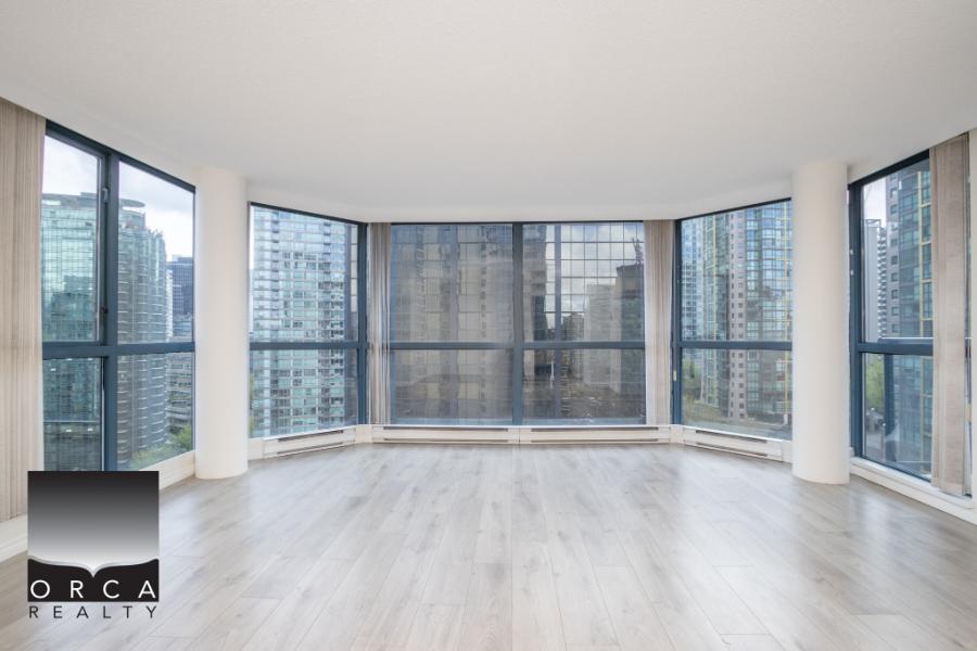 Bright modern high-rise condo with large floor-to-ceiling windows offering stunning city skyline views, open living space, and natural light, perfect for urban living in Vancouver.