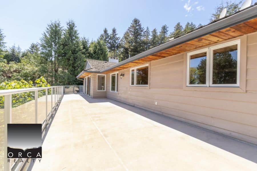 Bright spacious balcony with modern railing and scenic forest views in a premium Canadian residential property.