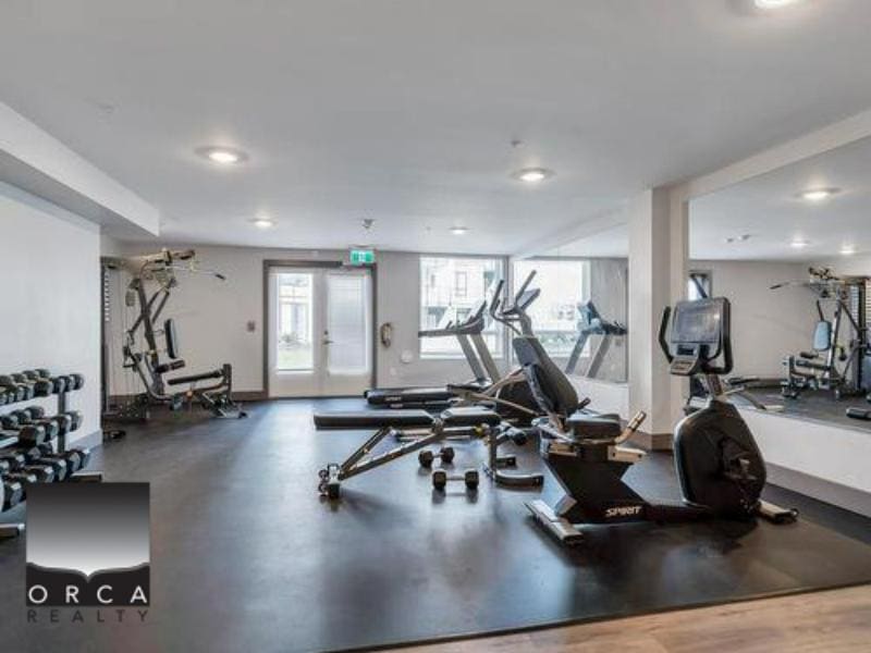 Modern fitness centre at Orca Realty Inc. offering gym equipment, weights, and cardio machines for residents and clients seeking convenient access to wellness facilities within the property.