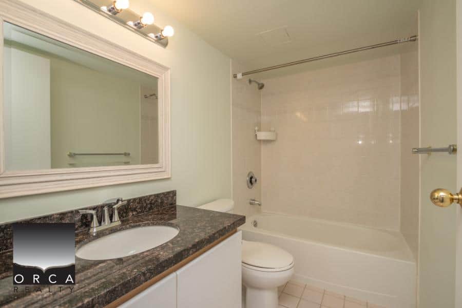 Clean modern bathroom with bathtub and vanity, perfect for Vancouver real estate listings, showcasing updated fixtures and neutral decor.