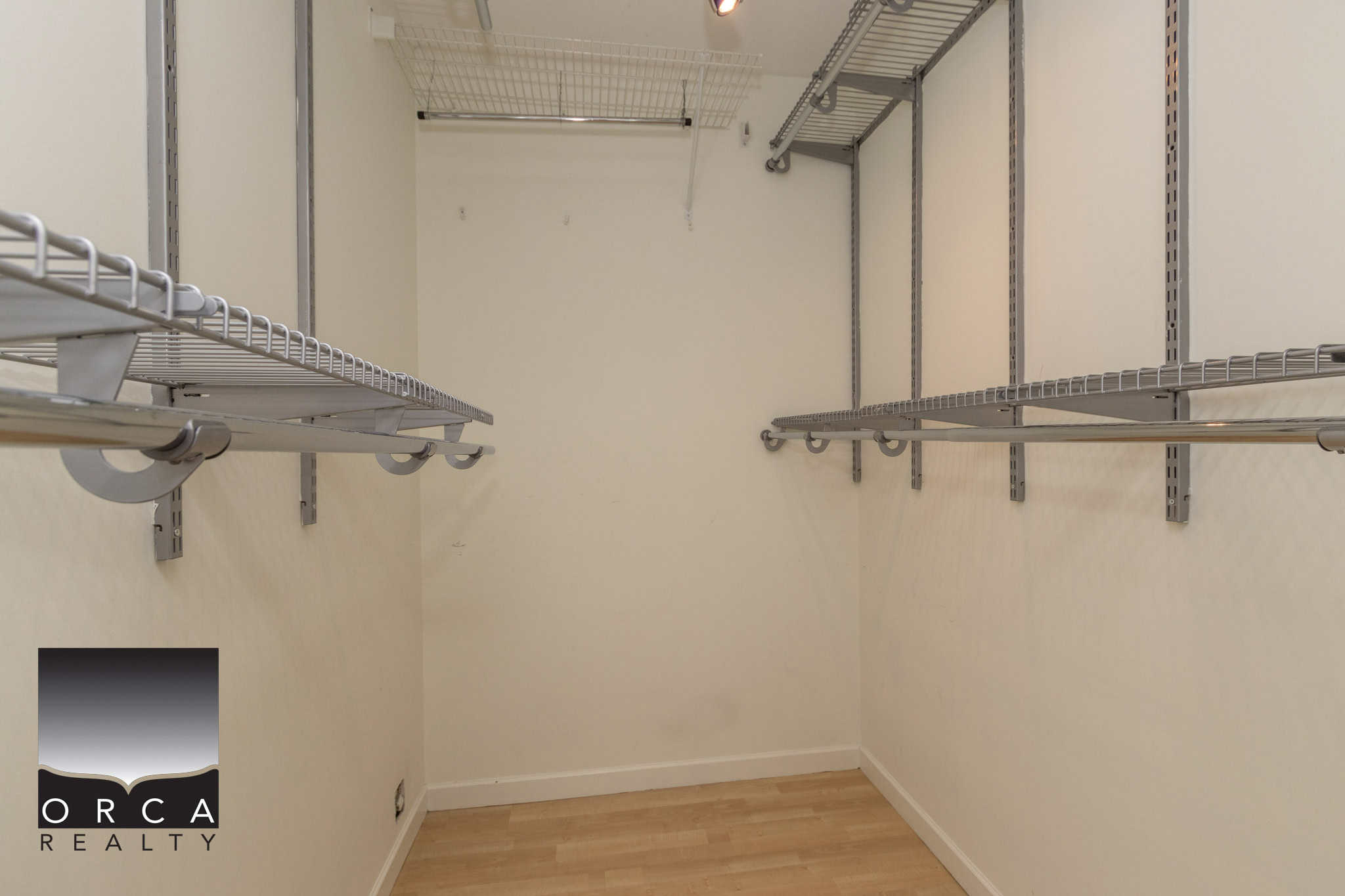 Spacious walk-in closet with organized wire shelving and rods, perfect for storage and wardrobe organization in a modern home.