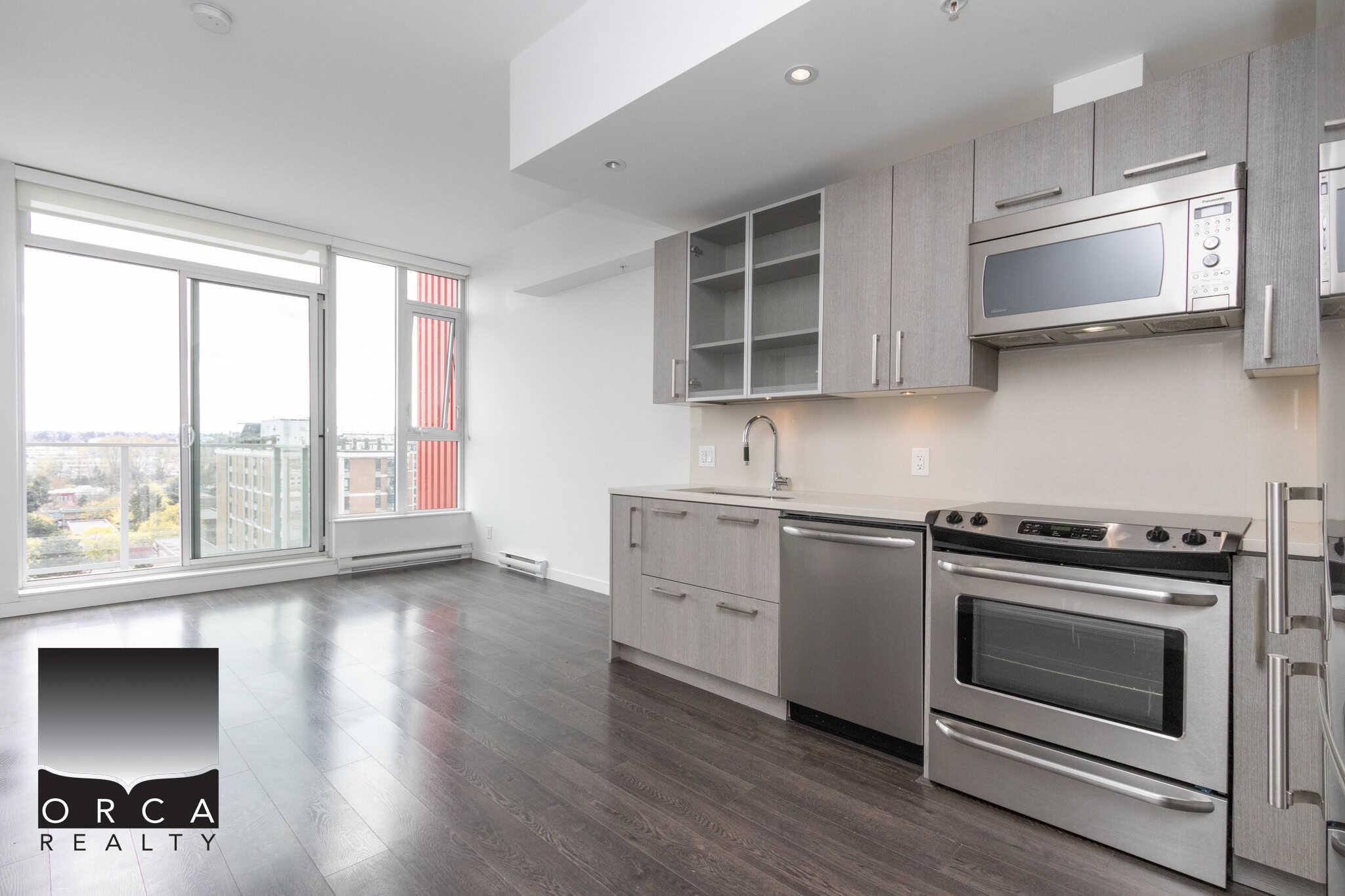 Modern downtown Vancouver condo with open-layout kitchen, stainless steel appliances, large windows, and stunning city views, perfect for urban lifestyle and real estate investment.