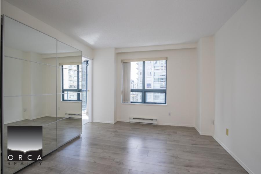 Bright, unfurnished Vancouver apartment with large windows, modern flooring, and a mirrored closet, ideal for comfortable city living and easy access to nearby amenities.