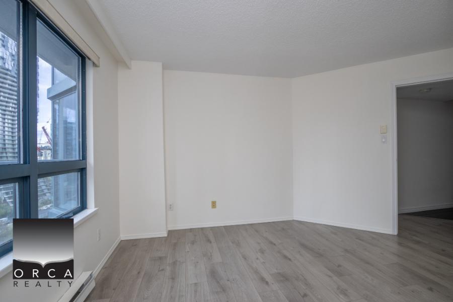 Bright, modern apartment interior with large windows, white walls, and laminate flooring, perfect for Toronto condos and rental properties.