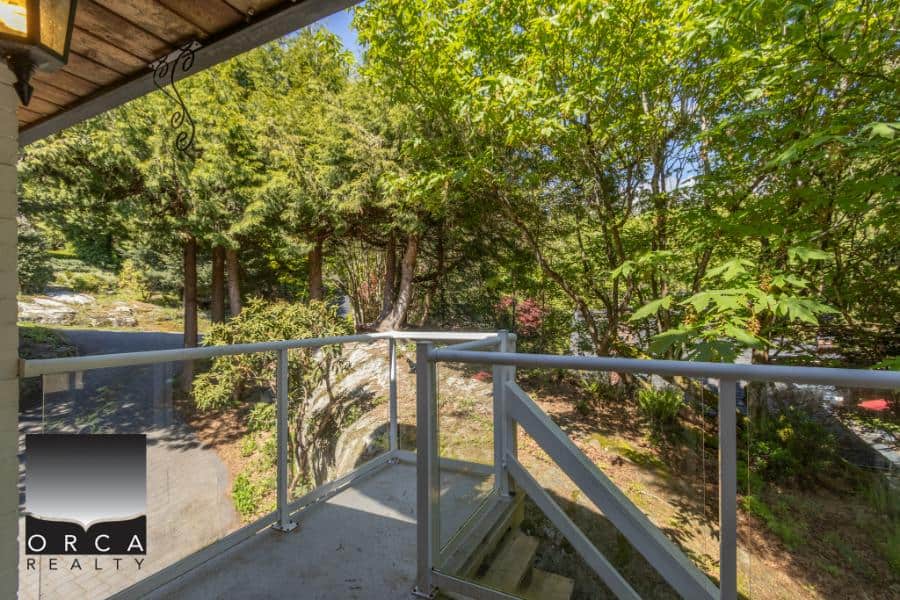 Lush green trees and a cozy balcony in a serene residential setting in Victoria, BC. Perfect for enjoying nature views and outdoor relaxation.