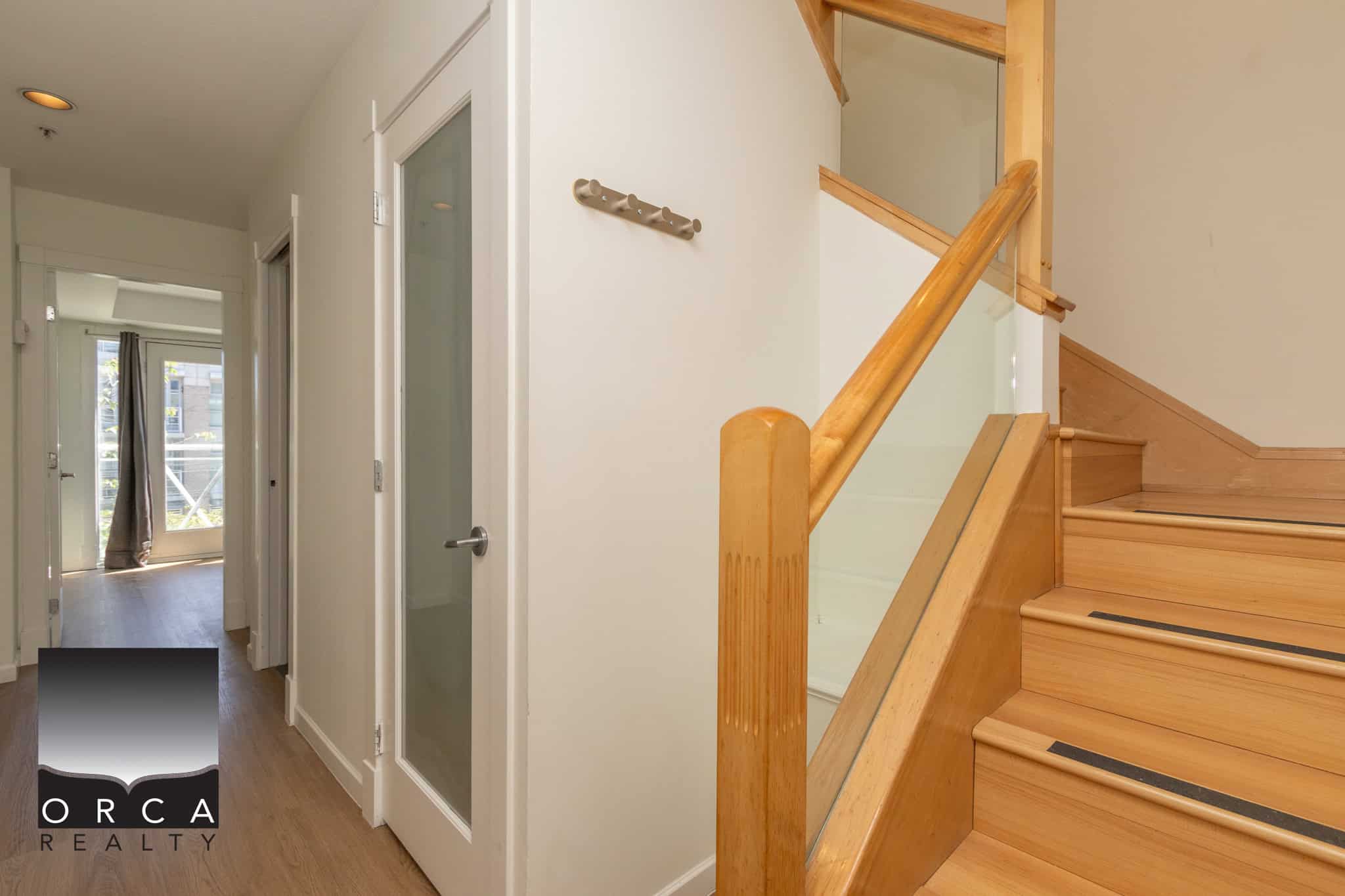Bright interior view of a modern Vancouver home showcasing the wooden staircase, white walls, and natural light, highlighting Orca Realty Inc.'s expertise in Vancouver real estate listings and property sales.