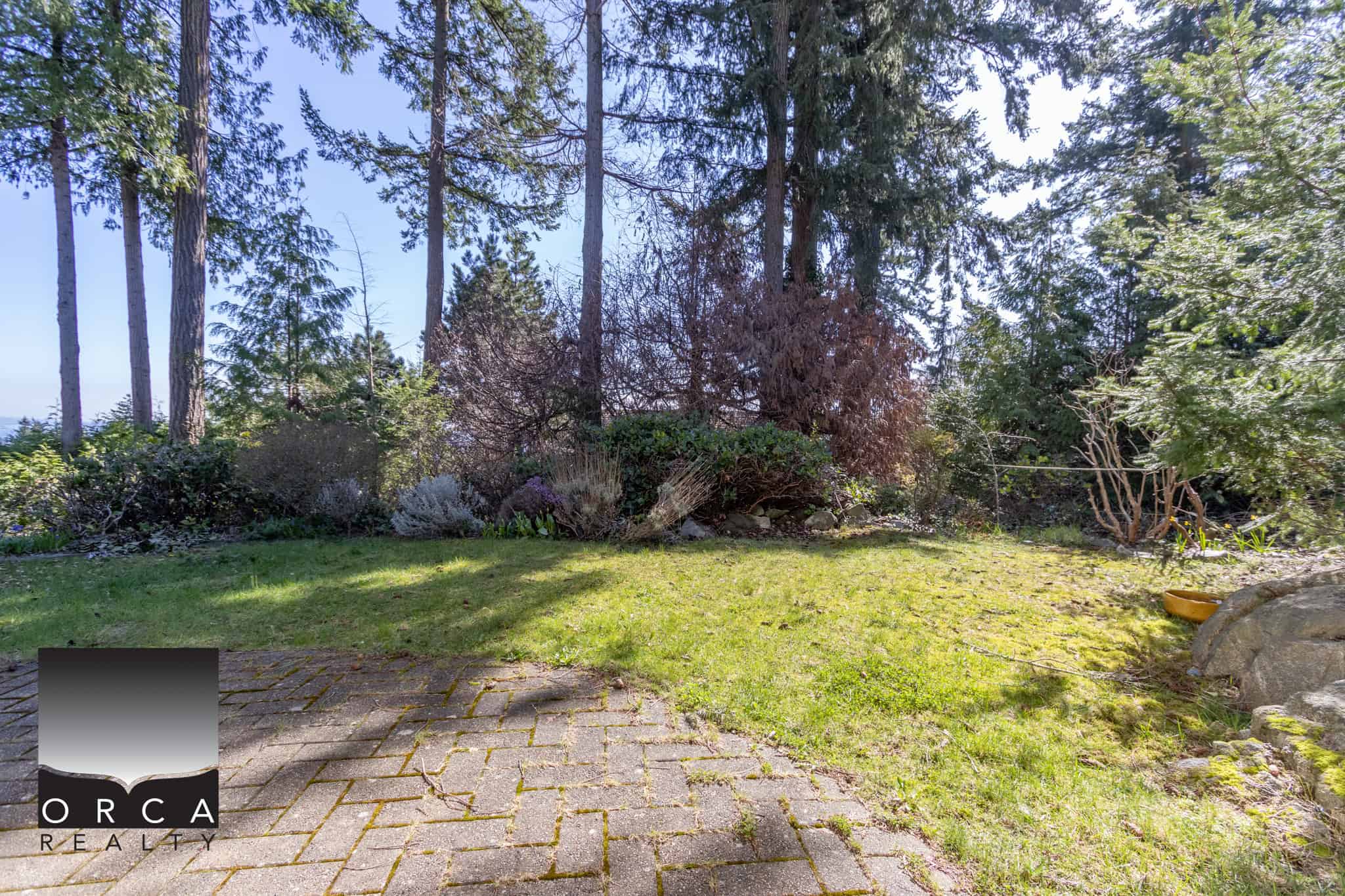 Lush backyard with vibrant greenery, mature trees, and well-maintained landscaping, ideal for outdoor living and relaxation. Perfect outdoor space for gardening, entertaining, or enjoying nature.