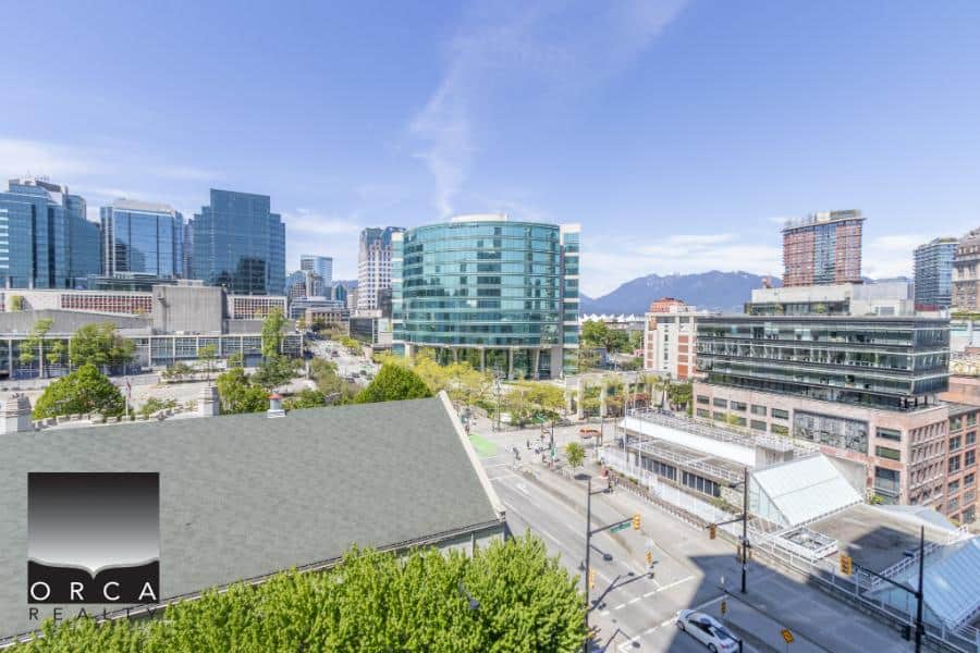 Office buildings and city skyline in downtown Vancouver, BC with mountain views, modern architecture, and urban development - ideal for real estate investment and property services.