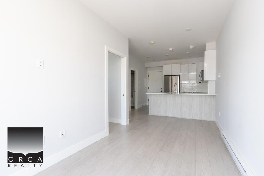 Bright modern open-concept living space with white walls and natural light, showcasing Orca Realty Inc.'s expertise in Vancouver Island real estate. Suitable for homebuyers and investors.