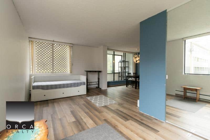 Bright living room with large windows and hardwood floors, modern interior design with minimal decor, open layout perfect for relaxation and entertaining, located in Vancouver, BC.