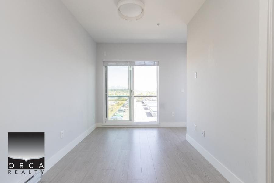 Bright modern apartment interior with large window showcasing city views, ideal for Vancouver real estate buyers.