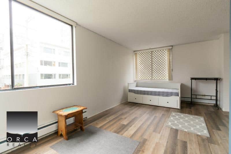 Bright Vancouver apartment with large windows, minimalist decor, ideal for urban living, in a pet-friendly building. Perfect for first-time homebuyers or investors looking for rental potential.