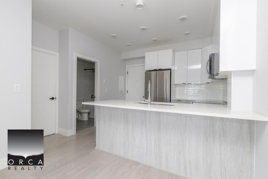 Bright modern kitchen with white cabinetry and stainless steel appliances, ideal for contemporary living. Open concept design perfect for family gatherings and entertaining guests.