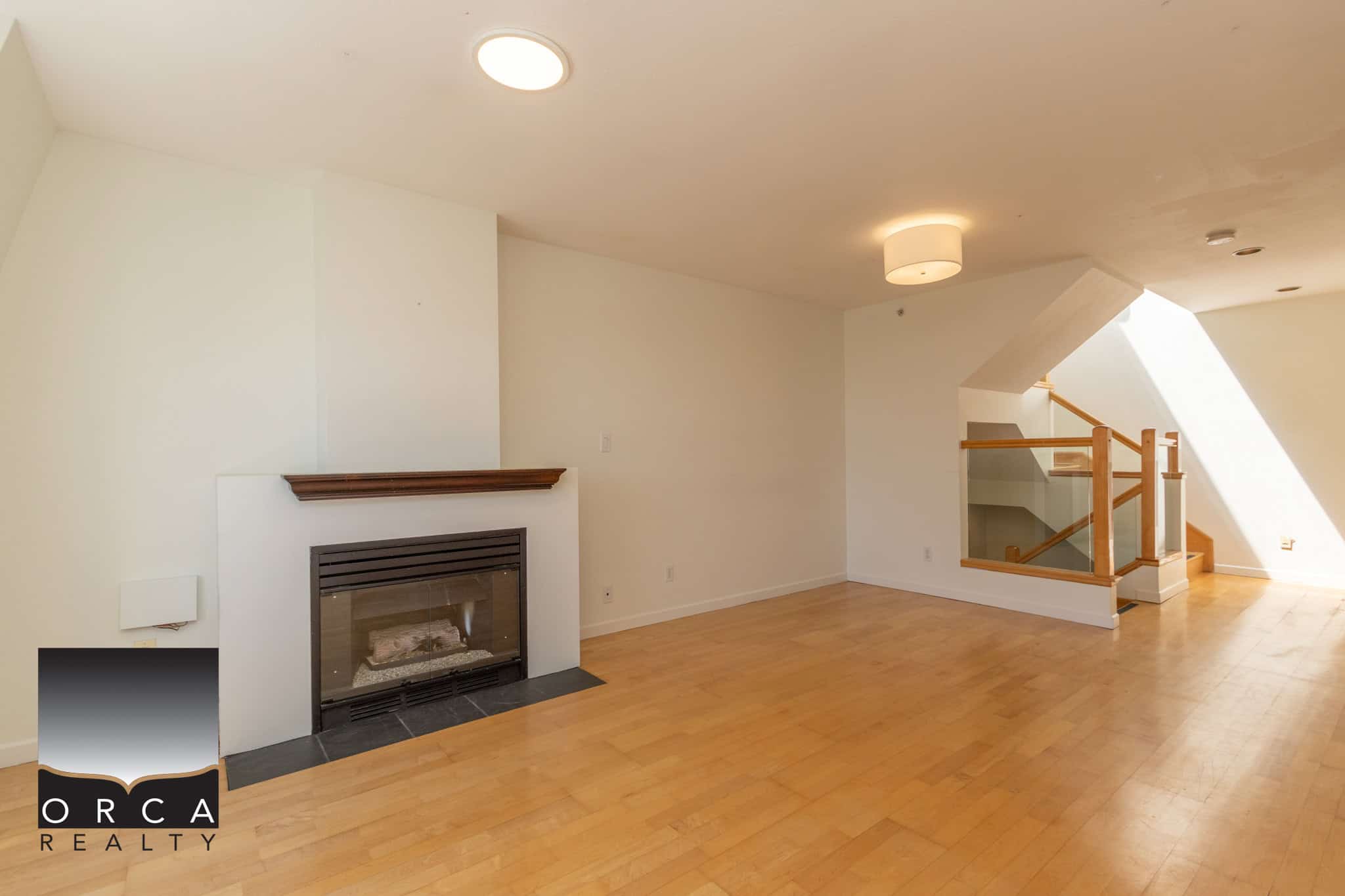 Spacious living room with fireplace and natural light, featuring hardwood floors and modern interior design, ideal for families and entertaining in Vancouver Island homes.