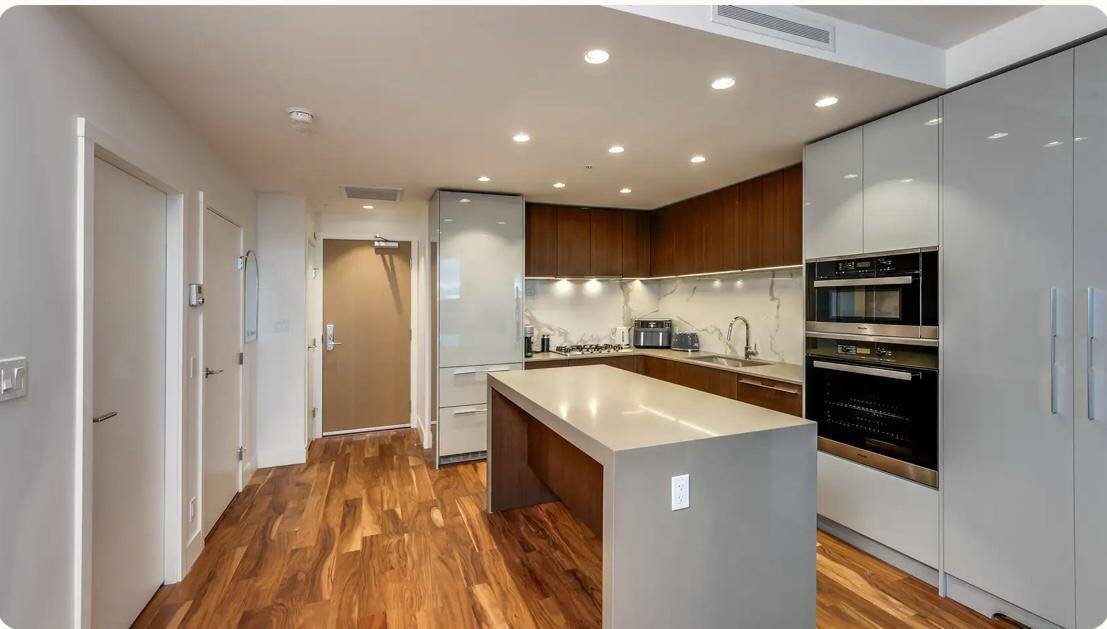 Contemporary kitchen with modern appliances, hardwood flooring, and sleek cabinetry, ideal for Vancouver real estate listings and premium property sales in BC.