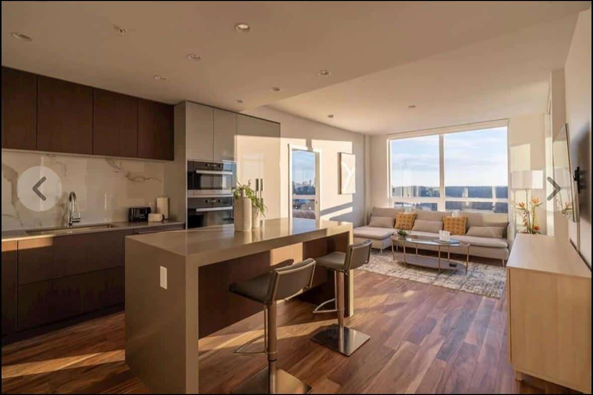 WhatsApp Image 2024-03-02 at 18.27.41 (6) Modern open-concept kitchen and living room with panoramic city views, hardwood floors, and contemporary decor, perfect for Vancouver real estate and luxury condo buyers.