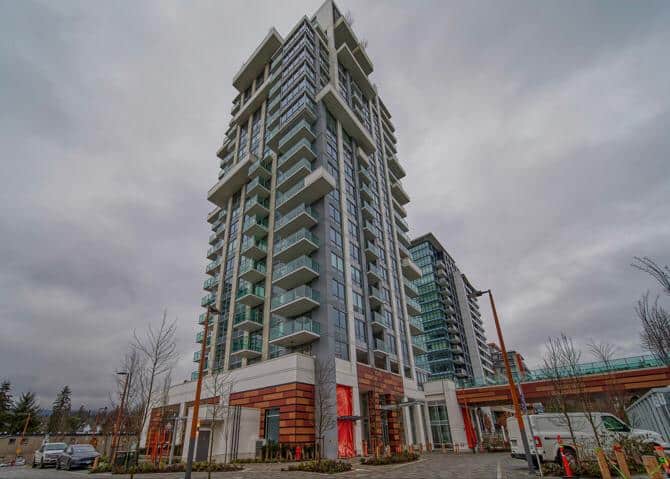 Modern high-rise condominium building with glass balconies in Vancouver, BC, showcasing contemporary urban living.