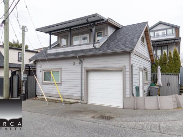 Modern duplex home with grey siding, attached garage, and urban backyard in Vancouver, featuring updated architecture, a comfortable residence, prime location, and excellent investment opportunity.