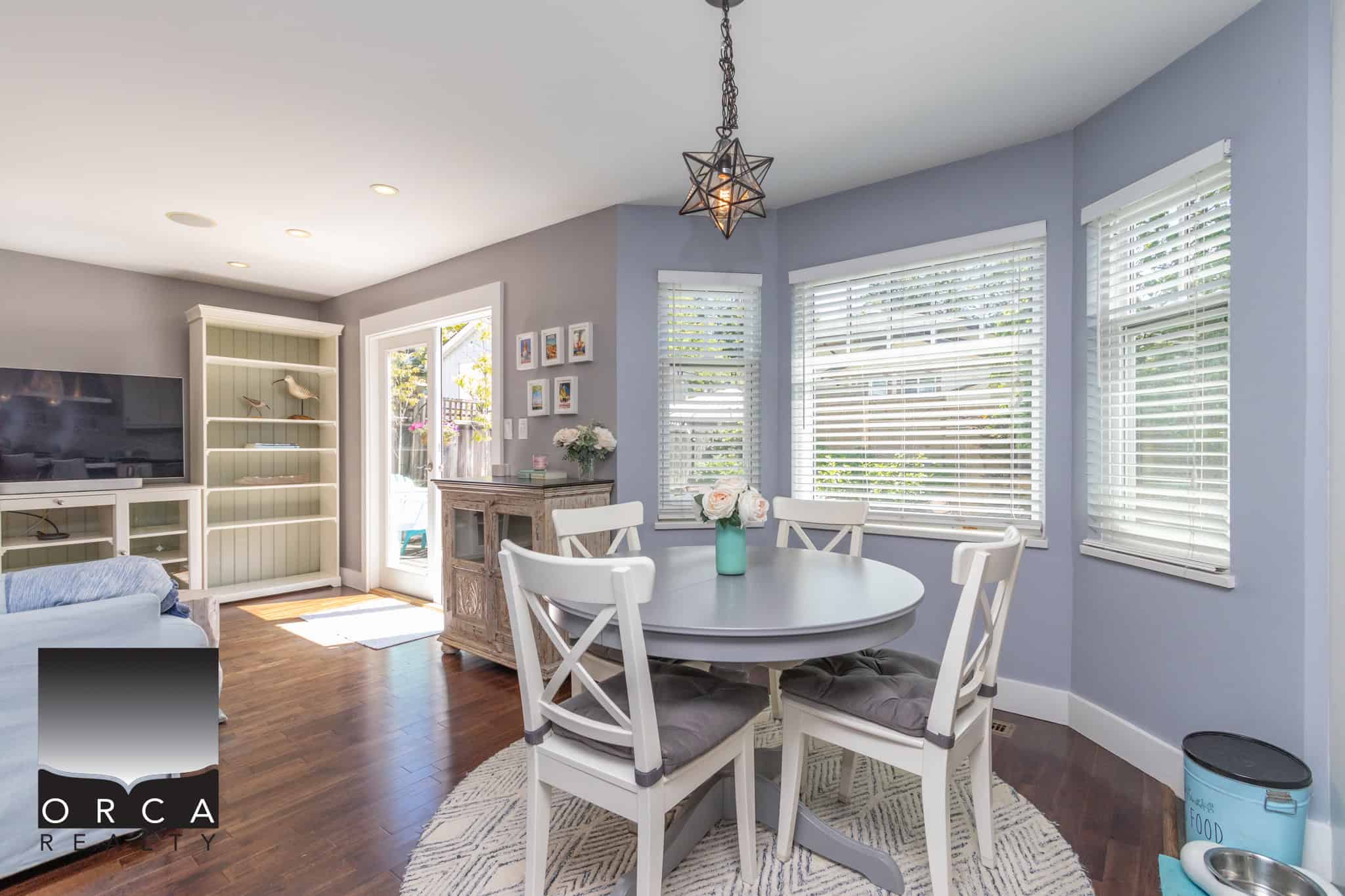 Cozy dining area with large windows, white furniture, and modern decor in a stylish Canadian home for real estate listing.