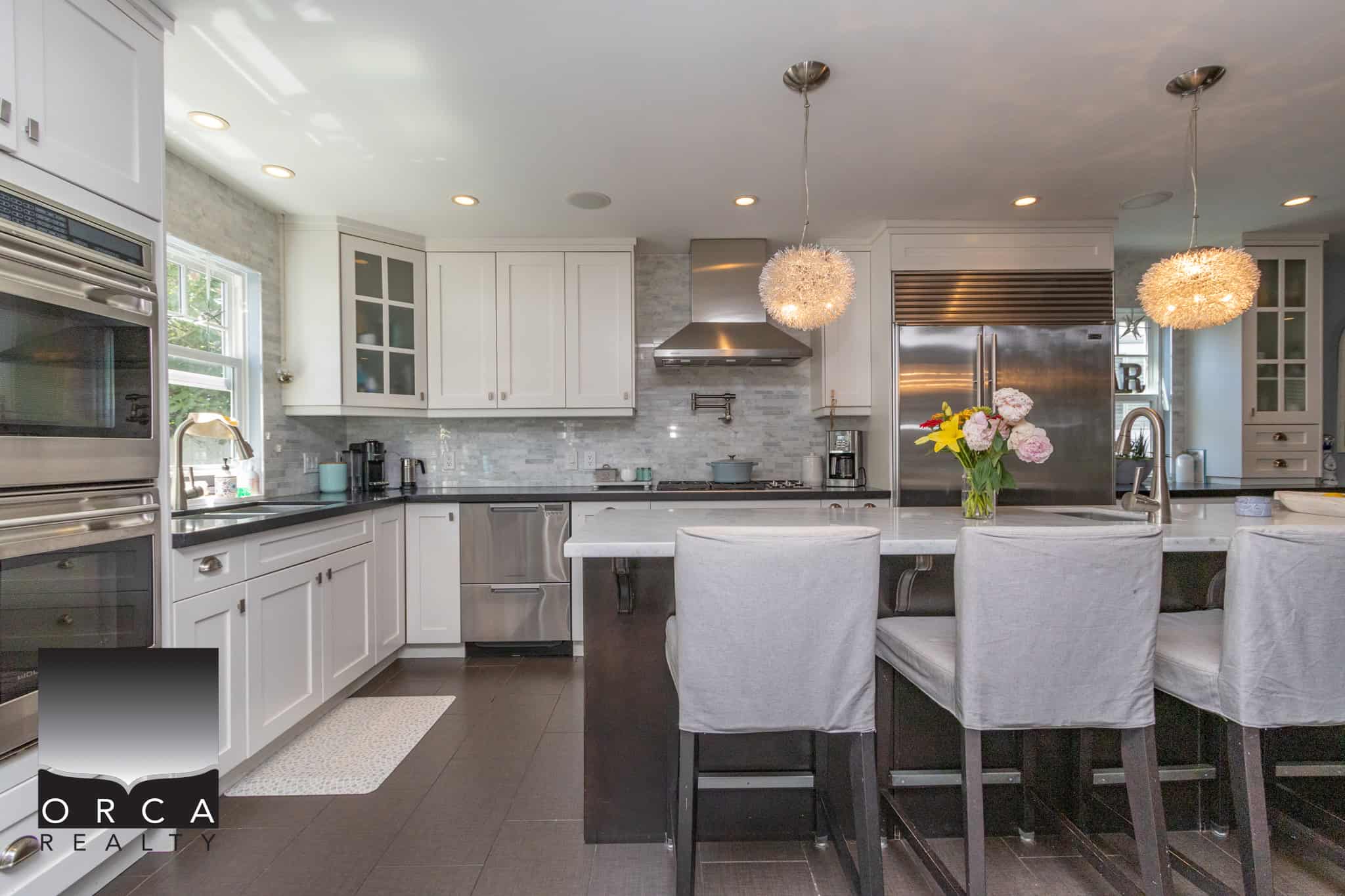 Bright, modern kitchen with white cabinetry, stainless steel appliances, and a spacious island, perfect for home renovation or property listing in Vancouver.