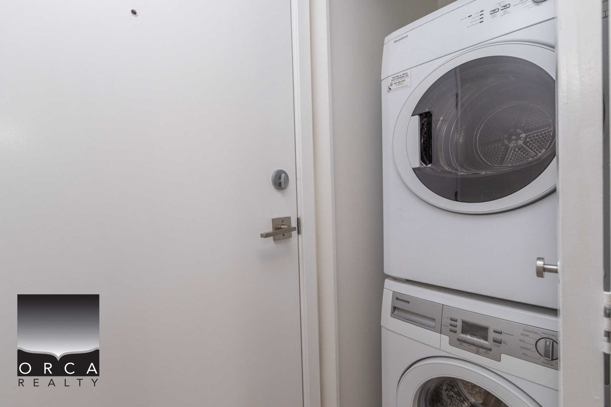 15 Modern laundry room with stacked washer and dryer in a contemporary condo or apartment, featuring white appliances and minimalistic design for efficient space utilization.