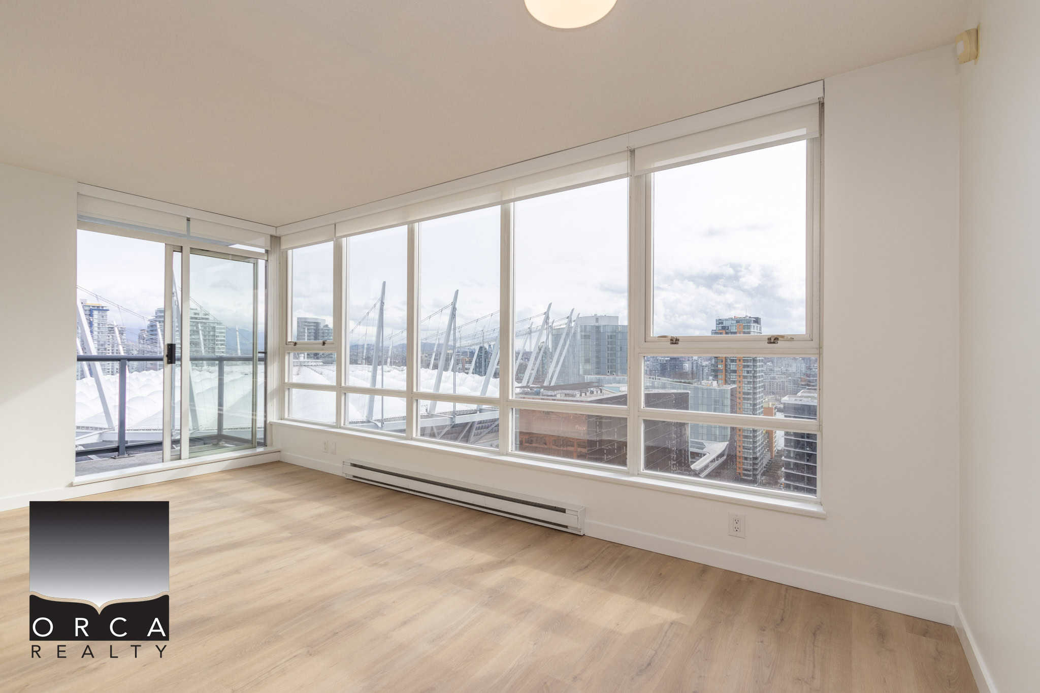 2 Bright open-concept living room with panoramic city and mountain Views, large windows, hardwood flooring, ideal for Vancouver Downtown condos or modern residential spaces.