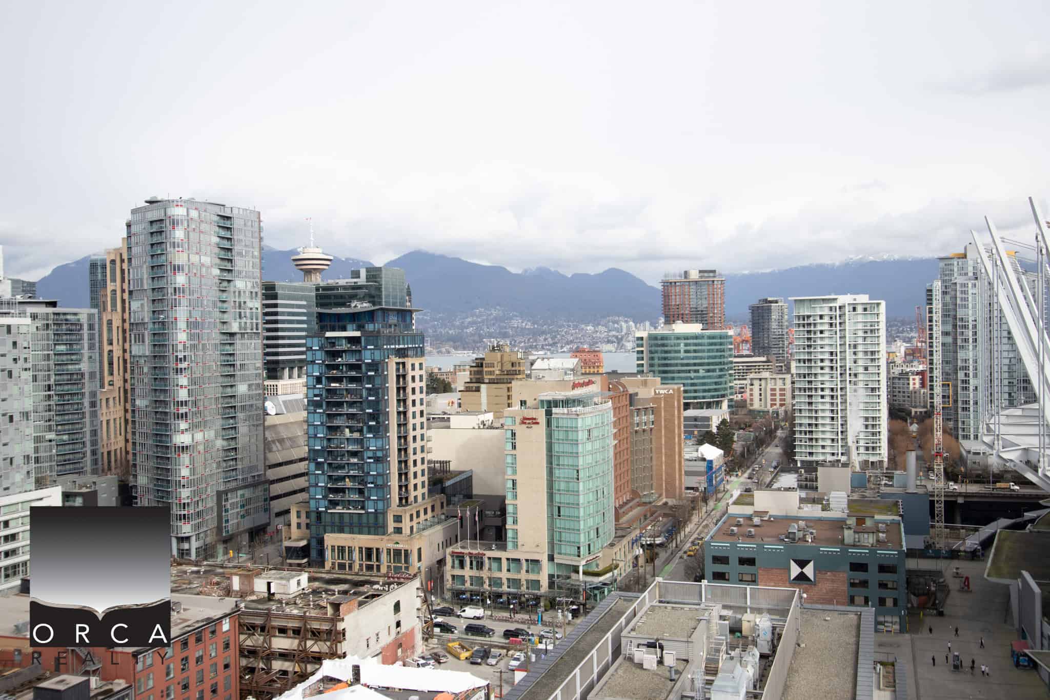4 Modern Vancouver skyline with high-rise condos and mountains in the background, showcasing urban living and real estate opportunities in the city.