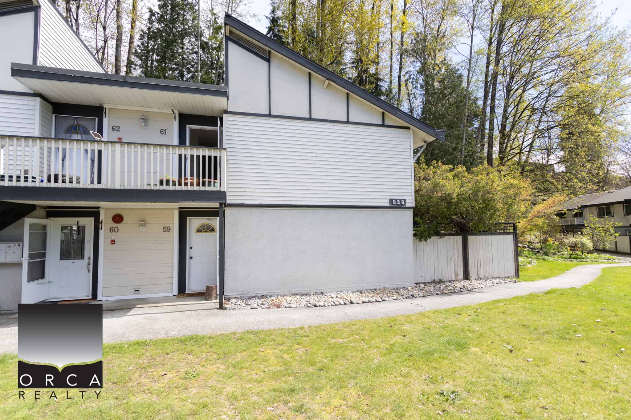 Modern multi-unit townhouse with a spacious balcony, located in a desirable residential area with lush greenery, perfect for real estate investment and family living in British Columbia.
