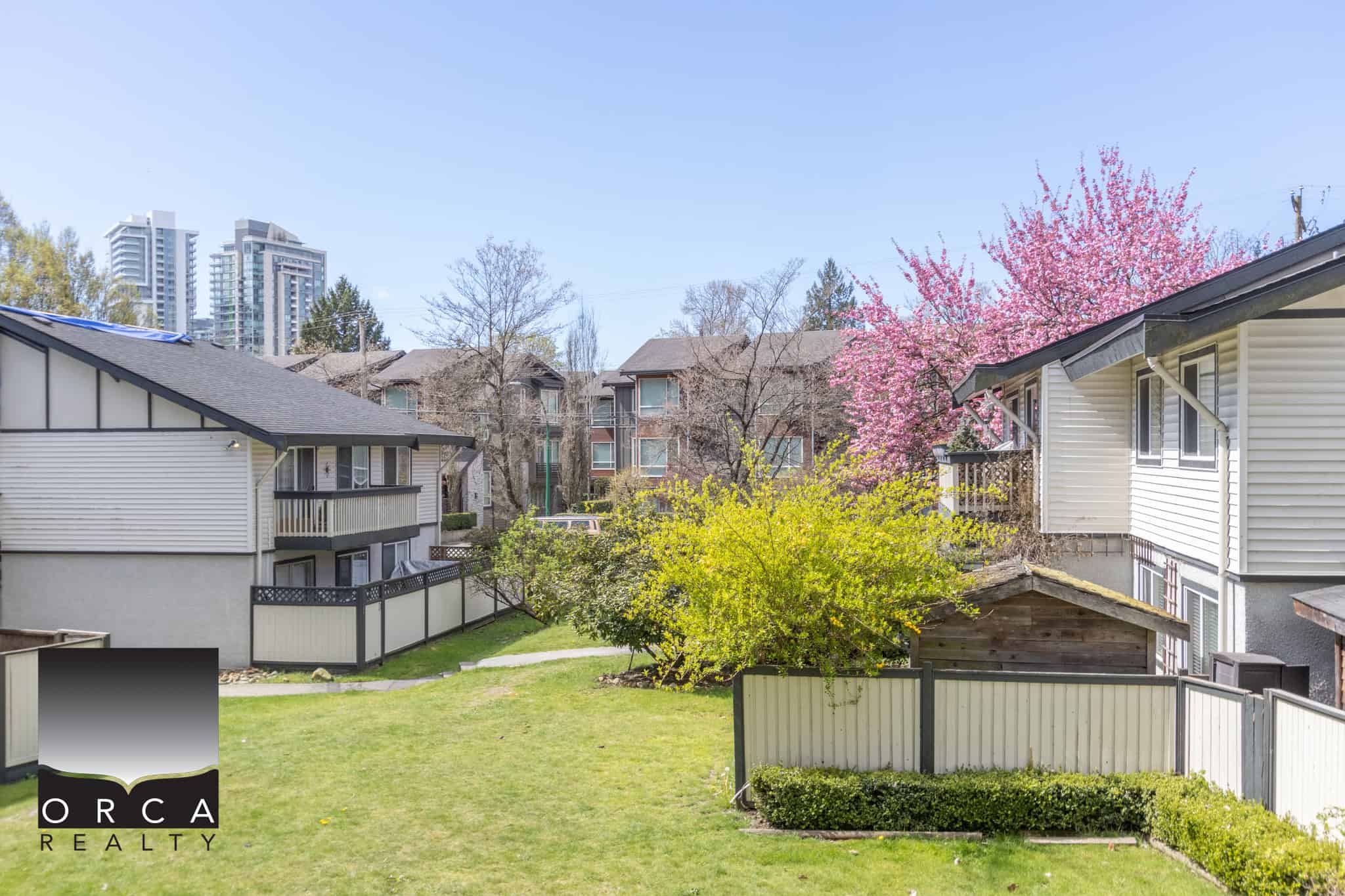 Lush backyard gardens and residential buildings in a Vancouver neighbourhood, showcasing scenic outdoor spaces ideal for real estate living and investment.