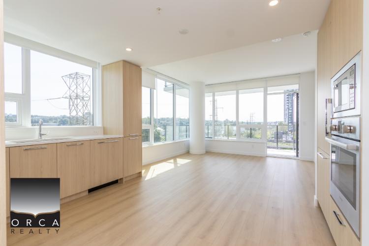 Bright modern condo interior with large windows and natural light in Vancouver, BC, showcasing contemporary kitchen and open living space by Orca Realty Inc.