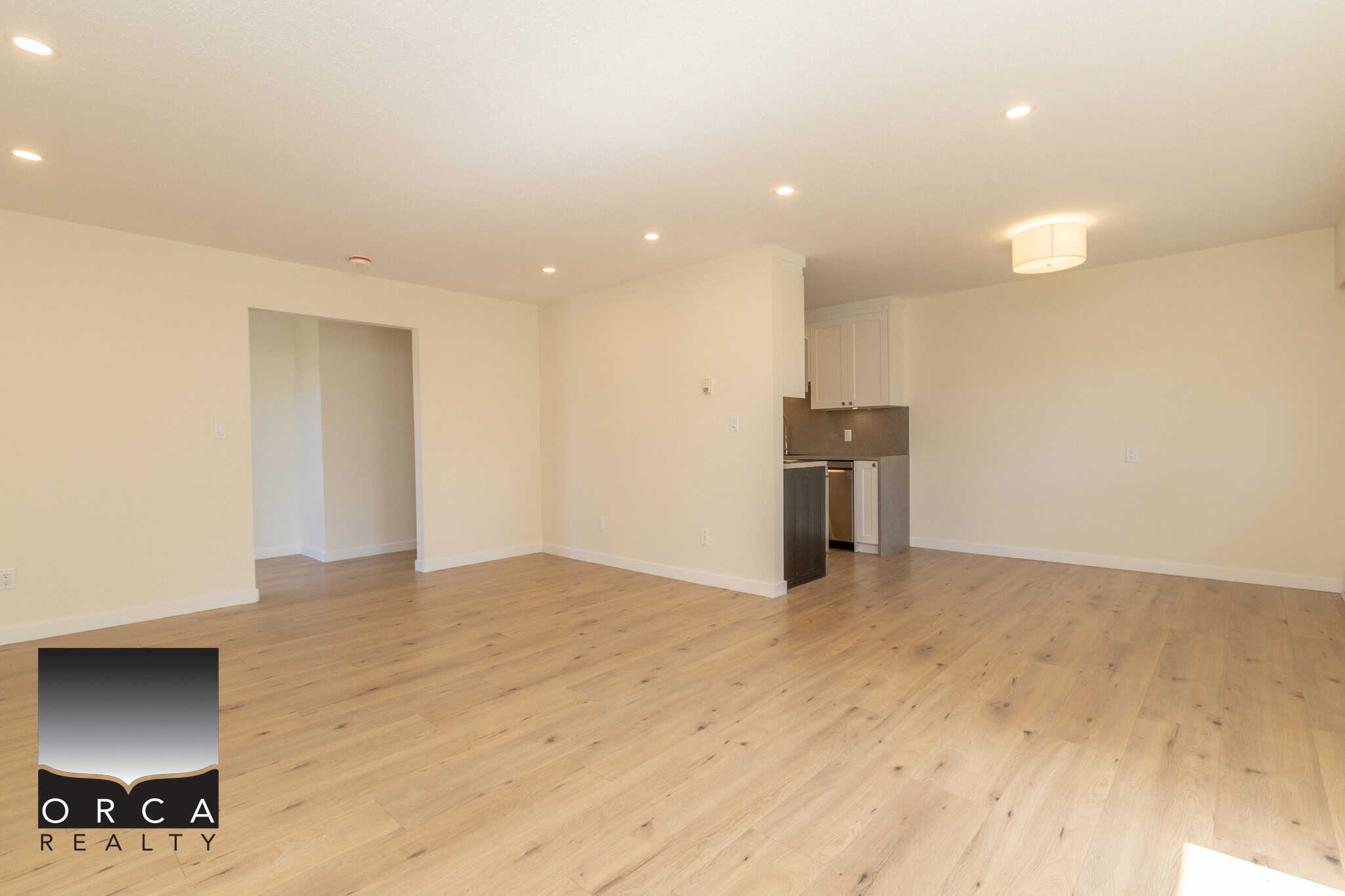 Bright, spacious open-concept living area with hardwood floors and modern kitchen, perfect for family living and entertaining in the Vancouver real estate market.
