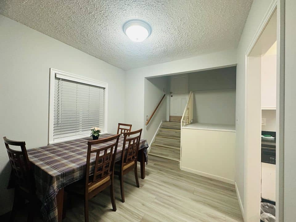Cozy dining area in Orca Realty Inc. listed property, showcasing a modern interior with a wooden dining table, comfortable chairs, and bright natural lighting.