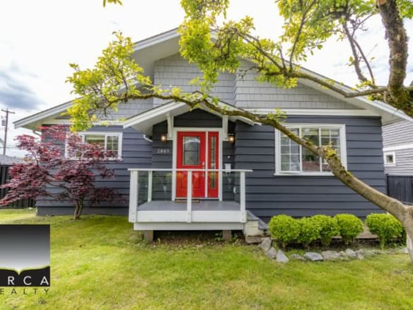 Charming modern house with a vibrant red front door, surrounded by lush greenery and mature trees, showcasing prime real estate listings by Orca Realty Inc. in Ontario.