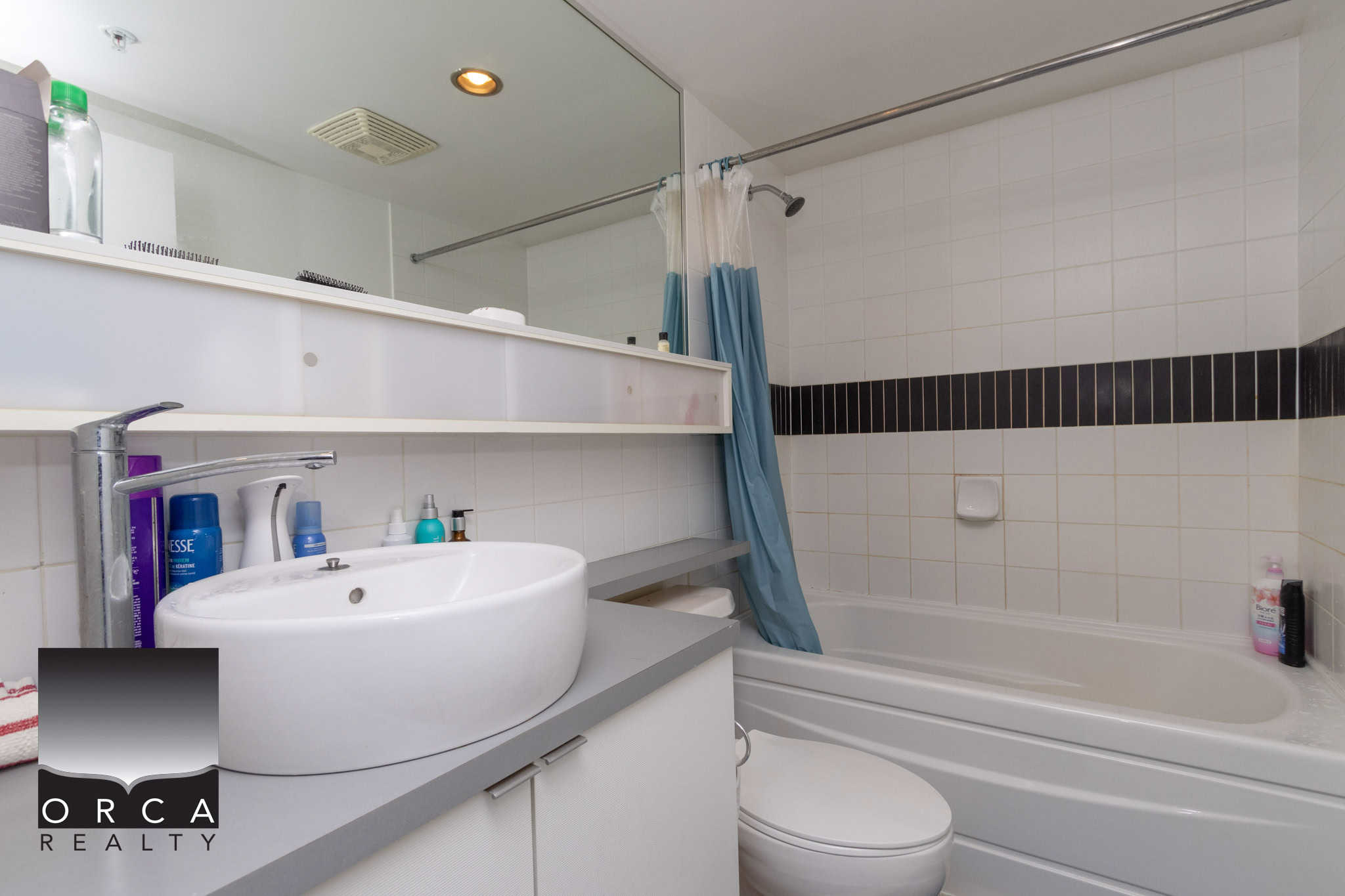 Modern bathroom with white tile accents, bathtub, and contemporary fixtures at Orca Realty Inc. Expertly designed for Vancouver Island real estate buyers and sellers.
