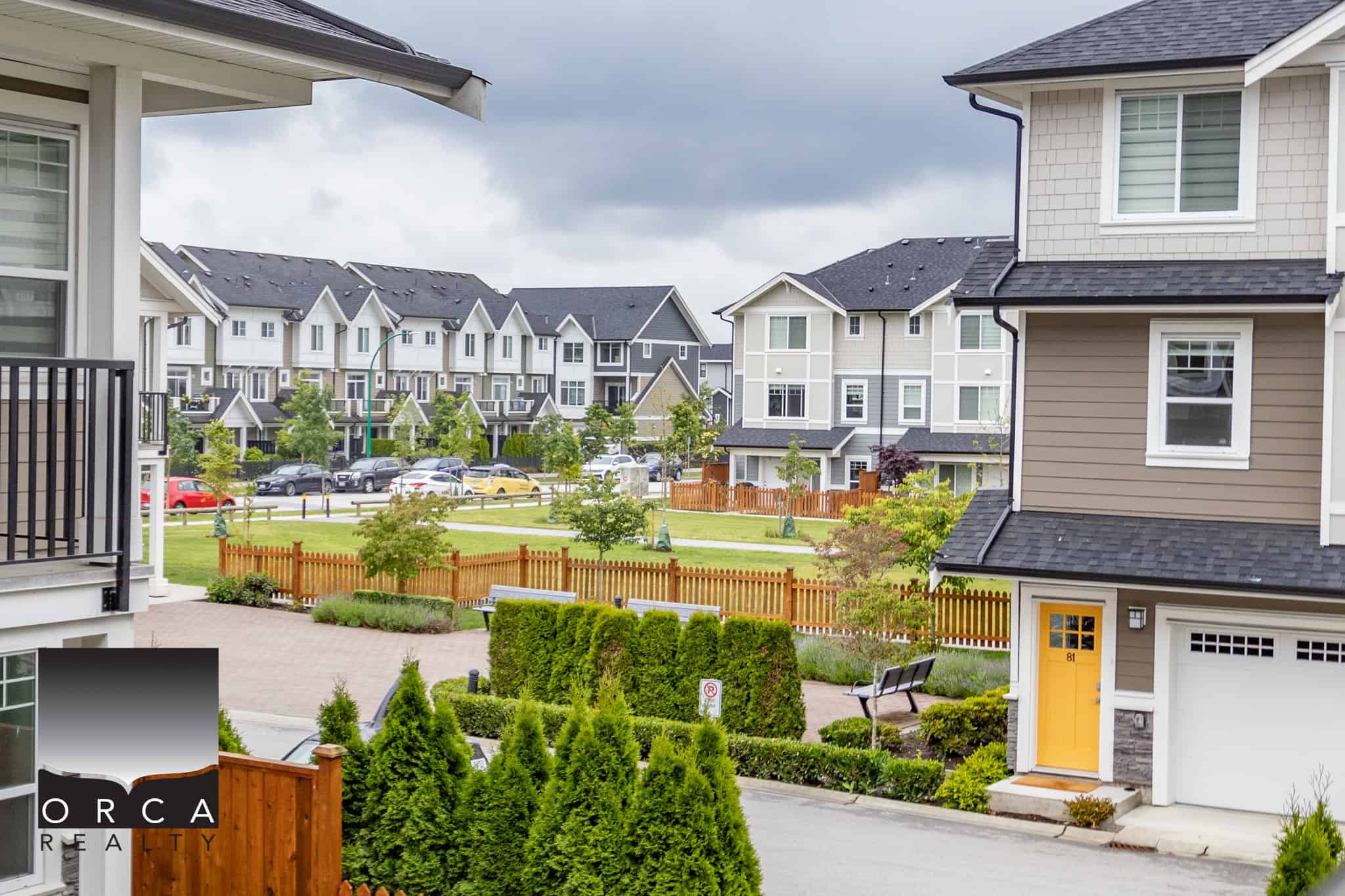11 Modern neighbourhood with contemporary townhouses, lush green lawns, and a fenced communal garden, offering ideal residential living options in a vibrant community.
