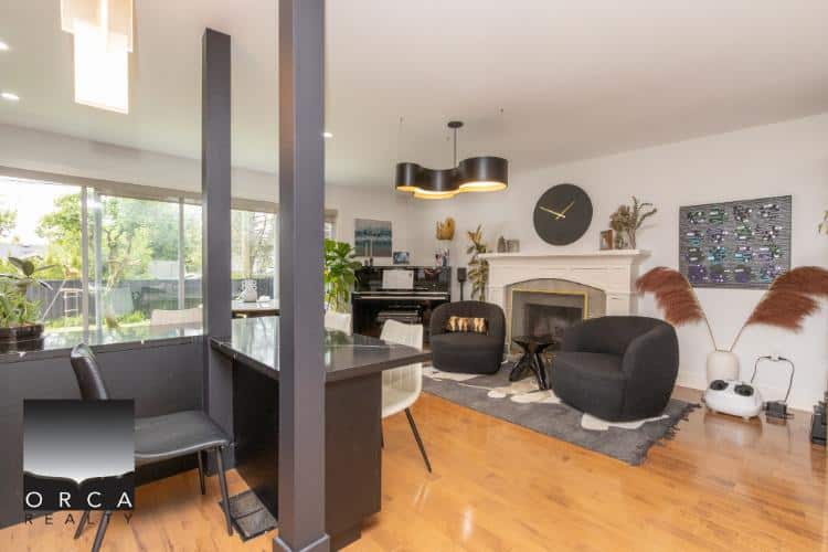 Spacious living room with modern furniture and abundant natural light, showcasing a cozy fireplace, stylish decor, and open-concept design perfect for Vancouver real estate.