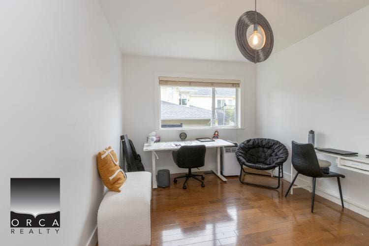 Cozy home office with white walls, wooden flooring, and modern furniture, perfect for remote work or studying in Vancouver. Bright space featuring a desk, comfy chair, and stylish decor.