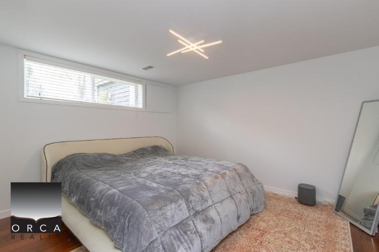 Bedroom with modern decor and natural light, real estate image from Orca Realty Inc., Vancouver property listing in Canada.